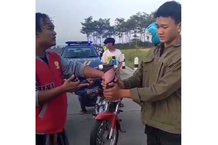 Tangkapan layar video menampilkan polisi berpakaian preman tengah memberi shock therapy ke pemuda yang akan membunyikan mercon di pintu keluar tol Duwet, Pekalongan, Jumat (23/4/2021) pagi.