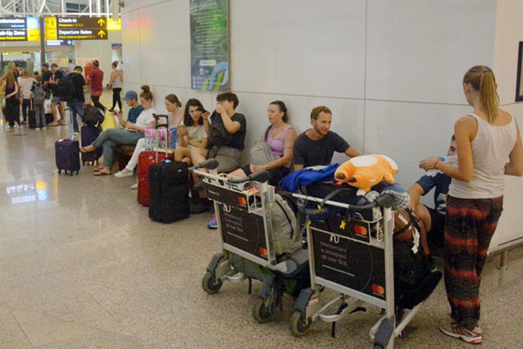 Sejumlah penumpang menunggu jadwal penerbangan di Terminal Internasional Bandara Ngurah Rai, Bali, Kamis (28/6). Sebanyak 3.571 penumpang dari 26 maskapai penerbangan domestik dan internasional terpaksa batal terbang karena dampak erupsi Gunung Agung yang terjadi pada Kamis (28/6/2018).  
