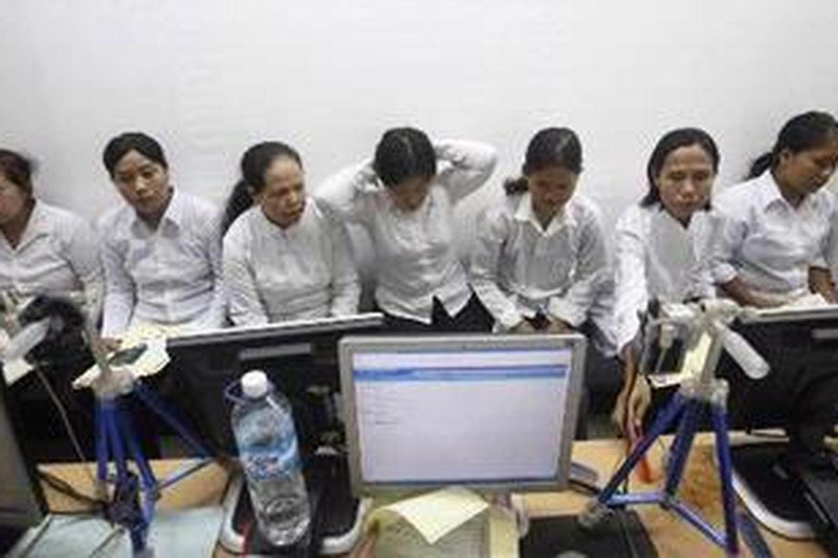 Calon tenaga kerja Indonesia (TKI) mengantre untuk foto paspor di kantor Direktorat Jenderal Imigrasi Unit Khusus, Departemen Hukum dan Hak Asasi Manusia Republik Indonesia, Tangerang, Banten, Rabu (22/6/2011). Setiap harinya sekitar 700 hingga 1.000 orang TKI yang akan bekerja di kawasan Timur Tengah mengurus paspor di tempat tersebut.