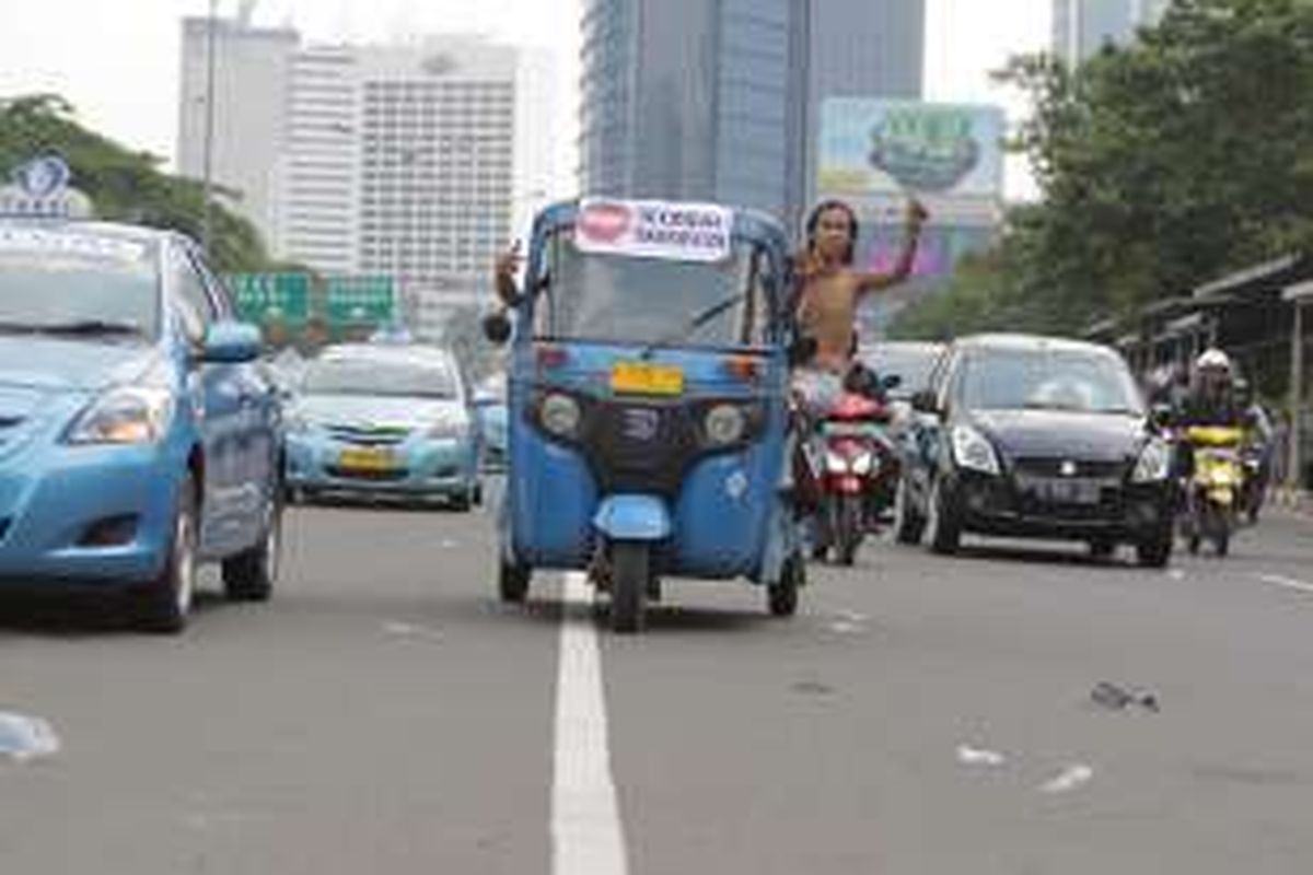 Gabungan sopir taksi dan bajaj melakukan aksi demonstrasi di sepanjang Jalan Sudirman, Jakarta, Selasa (22/3/2016). Mereka menuntut pemerintah menutup angkutan umum berbasis online karena dianggap mematikan mata pencaharian mereka.