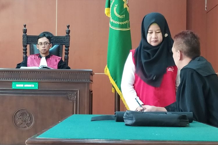 Terdakwa Sania Roulitas (47) berkonsultasi dengan kuasa hukum saat sidang di Pengadilan Negeri (PN) Banyumas, Jawa Tengah, Rabu (11/3/2020).