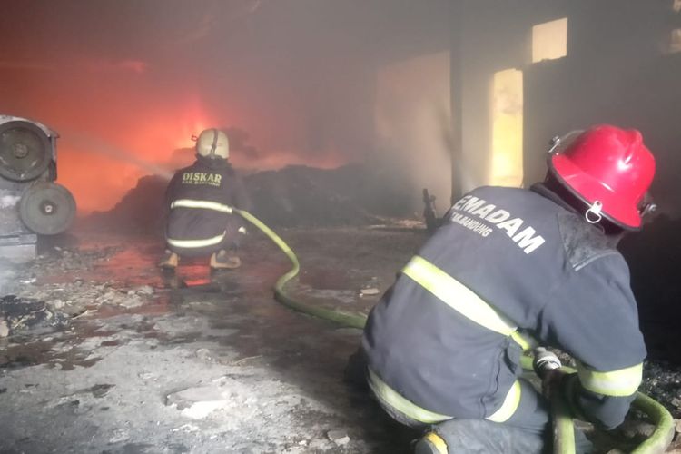Seorang petugas pemadam kebakaran sedang berupaya memadamkan api yang membakar pabrik majun di Katapang Kabupaten Bandung pada Kamis (7/4/2022) 