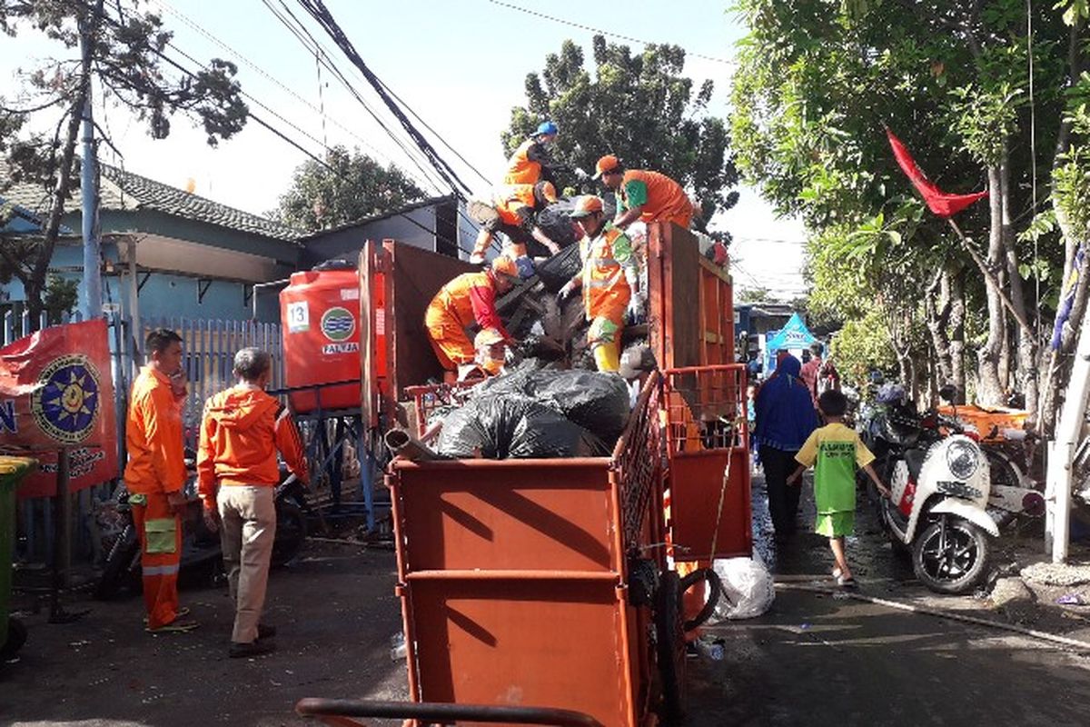 Petugas PPSU membersihkan sampah-sampah bekas kebakaran di Jalan Perumahan Taman Kota, RT 16 RW 05, Kebakatan Utara, Kebakaran, Jakarta Barat pada Senin (2/4/2018).