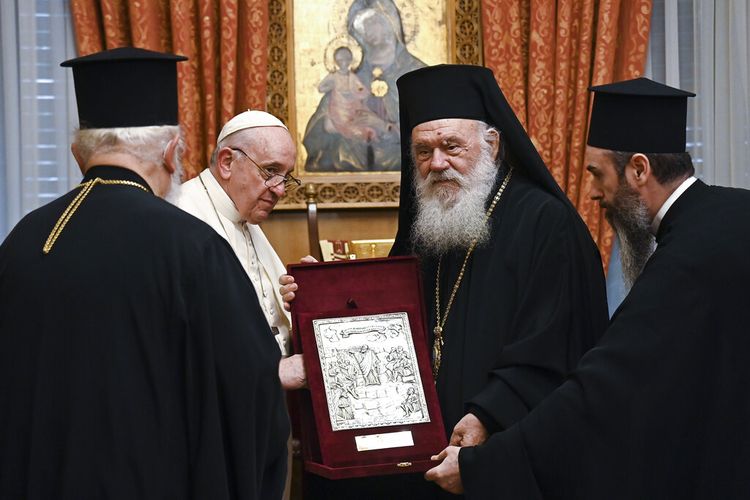 Paus Fransiskus, kedua dari kiri, menerima hadiah dari Uskup Agung Athena dan pemimpin Gereja Ortodoks Yunani, Ieronymos II saat ia tiba di keuskupan agung Ortodoks di Athena, Yunani, Sabtu, 04 Desember 2021.