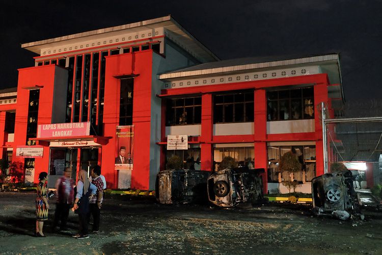 Petugas Lapas berada di depan Lapas Narkotika Kelas III Langkat pasca-kerusuhan yang terjadi, di Langkat, Sumatera Utara, Kamis (16/5/2019). Akibat peristiwa kerusuhan yang dilakukan para narapidana di Lapas tersebut mengakibatkan tiga mobil petugas rusak terbakar dan ratusan napi melarikan diri.