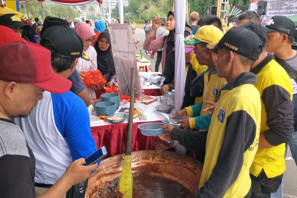 Sejumlah warga rela mengantre demi mendapatkan dodol betawi gratis di kawasan Monas, Jakarta Pusat, Sabtu (24/8/2019).