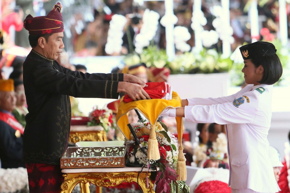 Presiden Joko widodo menyerahkan Bendera Merah Putih kepada Anggota Paskibraka Perwakilan dari Jawa Timur Fariza Putri S untuk dikibarkan dalam  Upacara Peringatan Detik-detik Proklamasi Kemerdekaan Republik Indonesia di Halaman depan Istana Merdeka, Jakarta, Kamis (17/8/2017).

Kompas/Wisnu Widiantoro (NUT)
17-08-2017