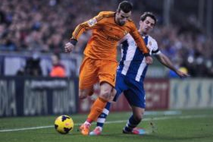 Gelandang Real Madrid, Gareth Bale (kiri), mencoba melepaskan diri kawalan dari pemain Espanyol, Victor Sanchez (kanan), pada laga Liga BBVA di Stadion Cornella-El Prat, Barcelona, Minggu (12/1/2014).