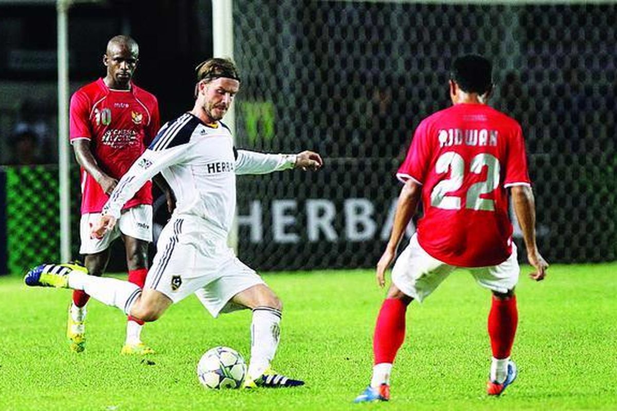 Pemain klub Los Angeles Galaxy, David Beckham (tengah), dibayangi pemain tim Indonesia Selection, M Ridwan (kanan), saat bertanding dalam laga ekshibisi di Stadion Utama Gelora Bung Karno, Jakarta, Rabu (30/11) malam. Los Angeles Galaxy menang 1-0.