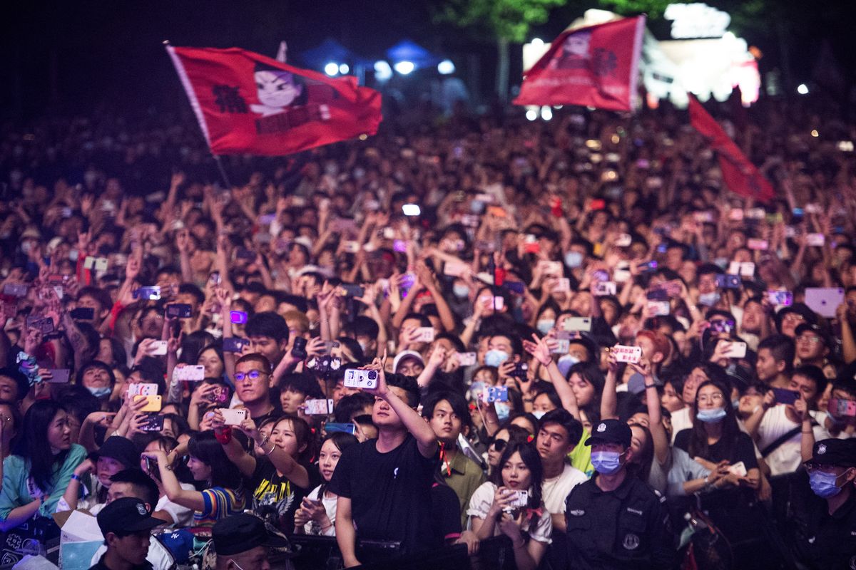 Masyarakat China dengan sedikit yang menggunakan masker saat menonton Strawberry Music Festival di Wuhan pada Sabtu (1/5/2021). [STR/AFP]
