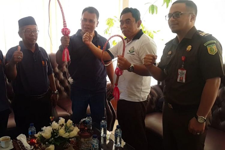 BERIKAN PECUT--Budi Santoso (kiri) memberikan pecut menyindir Kejaksaan Negeri Mejayan yang tidak berani menahan dua tersangka kasus korupsi pengelolaan dana sampah Badan Lingkungan Hidup Kabupaten Madiun senilai Rp 2 milyar pada Hari Anti Korupsi Sedunia, Senin ( 10/12/2018) siang.