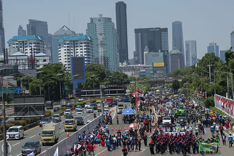 Massa buruh berjalan kaki saat akan berunjuk rasa di depan kompleks Parlemen, Senayan, Jakarta, Selasa (25/8/2020). Dalam aksinya itu ribuan buruh menolak omnibus law draf pemerintah dan menuntut agar PHK massal dampak COVID-19 dihentikan.
