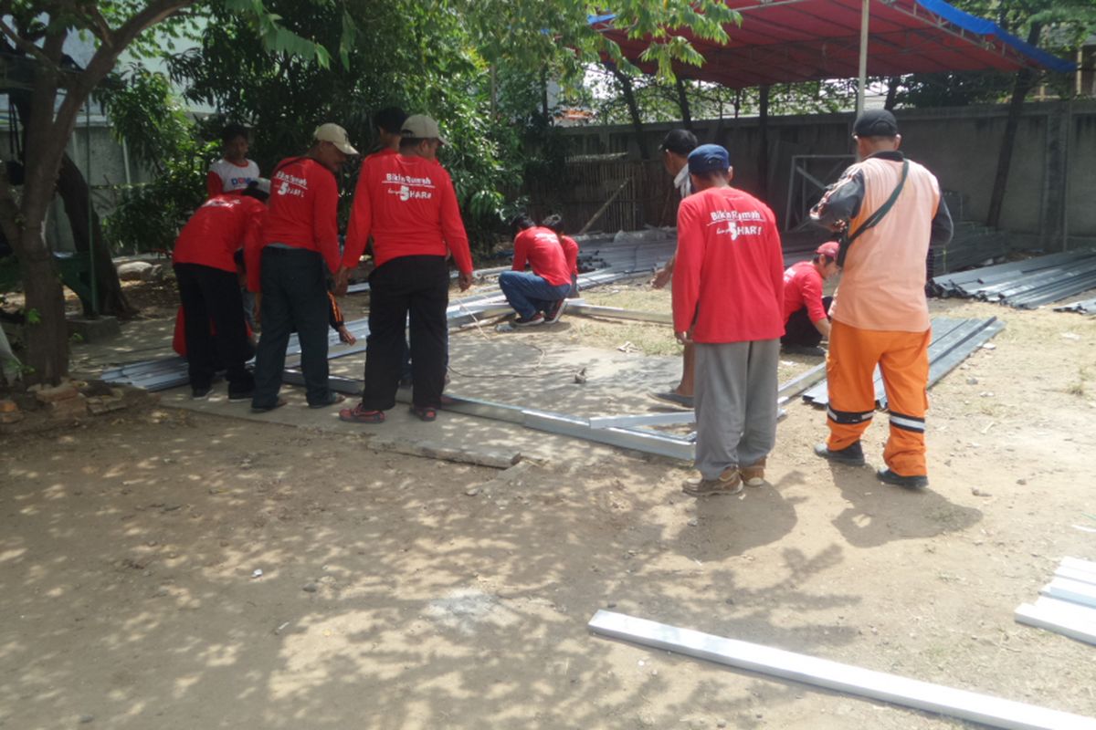Petugas PPSU dan Pasukan Merah sedang mengerjakan rangka bangunan rumah dari baja ringan. Pasukan merah merupakan petugas yang didatangkan oleh PT Tatalogam selaku pemberi CSR pembangunan bedah rumah yang dicanangkan Pemprov DKI di Cilincing, Jakarta Utara, Jumat (28/4/2017)