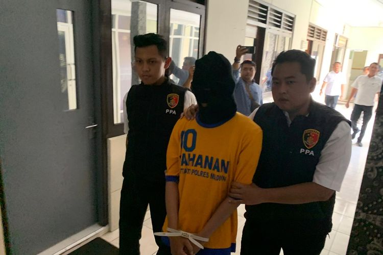 DITANGKAP—Tim Satreskrim Polres Madiun menggiring tersangka V, pria pembuang bayi hasil hubungan gelapnya dengan pacarnya E di Sungai Sono, Desa Tiron, Kecamatan Madiun, Kabupaten Madiun, Jawa Timur, Senin (13/1/2025).