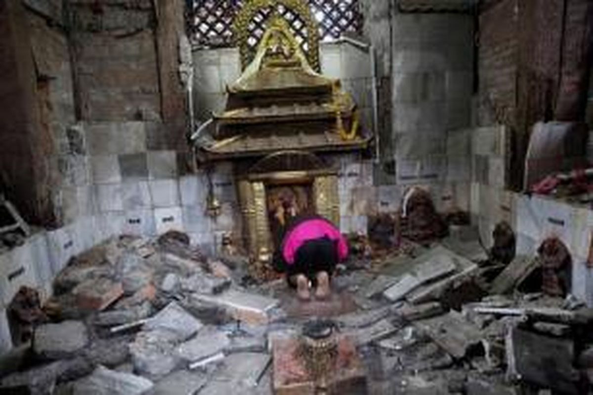 Warga berdoa di Kuil Indrayani yang hancur diamuk gempa di Kathmandu, Nepal, 27 April 2015. Gempa tektonik berkekuatan 7.9 SR mengguncang Nepal pada 25 April, mengakibatkan ribuan orang meninggal.