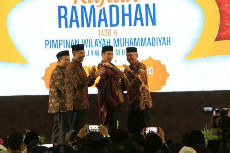 Anggota Dewan Pertimbangan Presiden, Abdul Malik Fadjar, didampingi Menteri Pendidikan dan Kebudayaan, Muhadjir Effendy, dan Rektor UMM, Fauzan, saat memakaikan jas almamater UMM kepada Presiden Joko Widodo dalam Kajian Ramadhan Pimpinan Wilayah Muhammadiyah Jawa Timur di UMM, Sabtu (3/6/2017) 