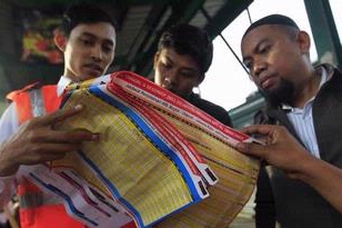 Petugas menunjukkan jadwal baru kereta rel listrik (KRL) di Stasiun Manggarai, Jakarta, Kamis (1/12/2011). Hari ini PT Kereta Api Indonesia melakukan uji coba pola baru KRL dan akan resmi beroperasi pada 5 Desember 2011. Dengan pola baru, titik rawan kepadatan penumpang diperkirakan akan terjadi di stasiun transit penumpang, yakni Manggarai, Tanah Abang, Duri, Kampung Bandan, dan Jatinegara. 