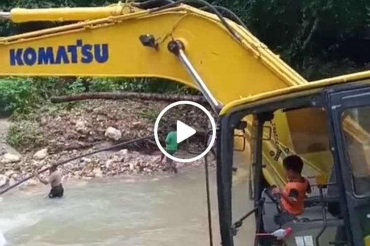 Theo Paays, bocah lima tahun asal Desa Amahusi, Kecamatan Leitimur Selatan, Ambon saat mengoperasikan eskavator untuk membersihkan puinh jembatan dan bebatuan di sungai di desanya, Minggu (4/10/2020)