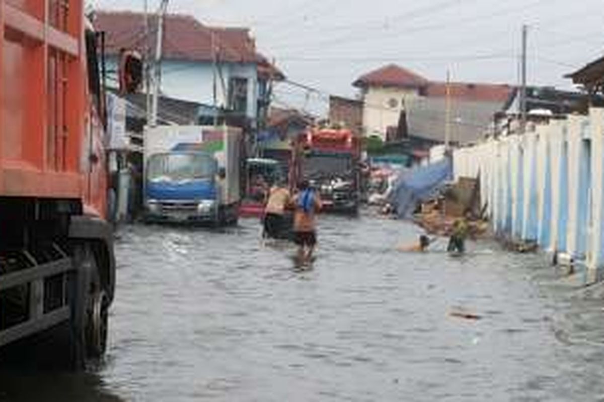 Banjir rob yang sedang terjadi di Kelurahan Muara Angke, Penjaringan, Jakarta Utara, Selasa (10/1/2017). Ketinggian banjir rob di Muara Angke terpantau mencapai sekitar 5 sentimeter. Banjir rob menyebabkan tergenangnya jalan akses yang menghubungkan Pasar Muara Angke dengan Pelabuhan Kali Adem.