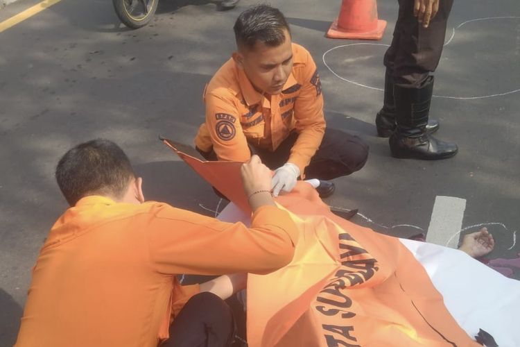 Petugas mengevakuasi jenazah pria paruh baya korban kecelakaan di Surabaya, Rabu (31/1/2024). Korban yang mengendarai sepeda angin ditabrak sepeda motor.