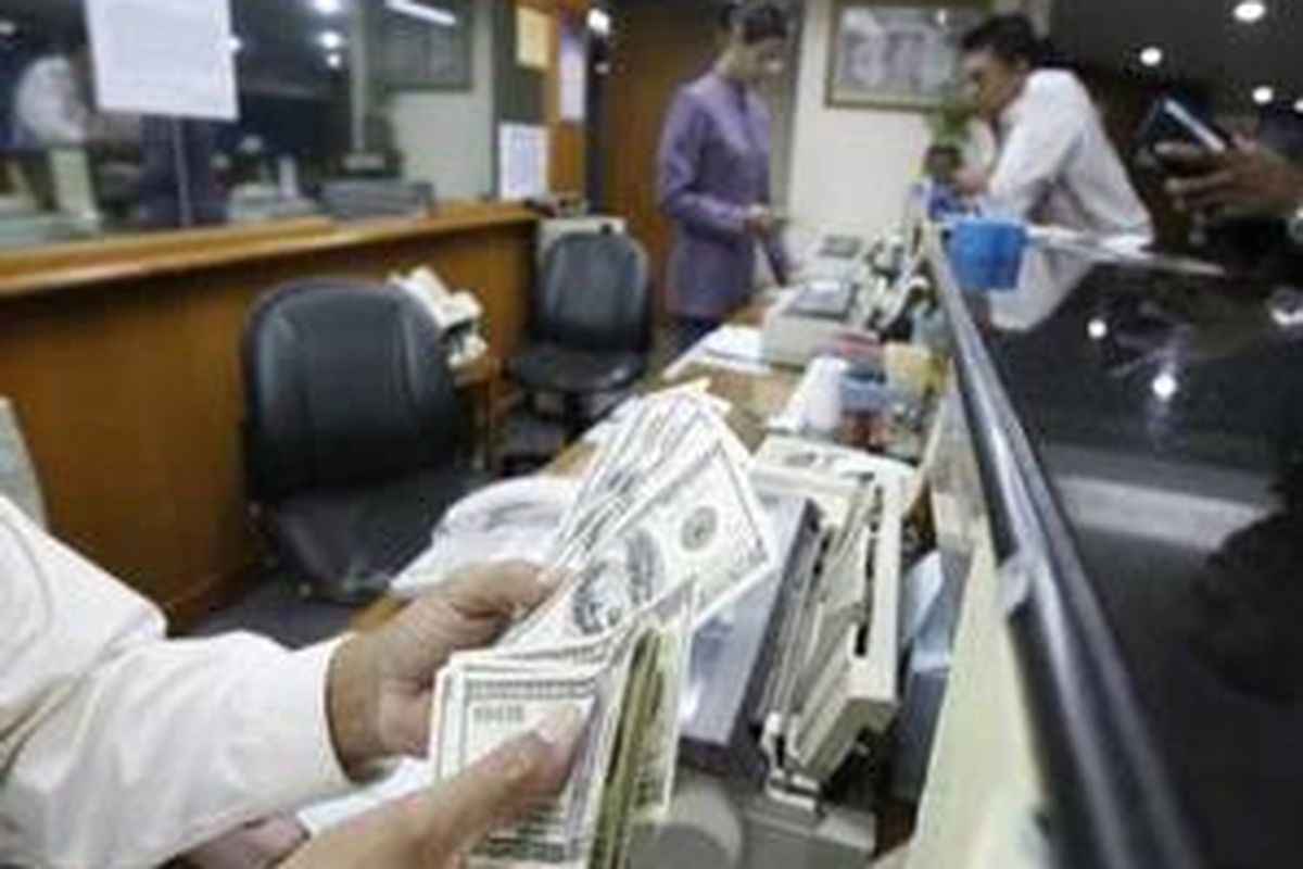 Staf penukaran valuta asing di Kwitang, Jakarta menghitung mata uang dollar AS.