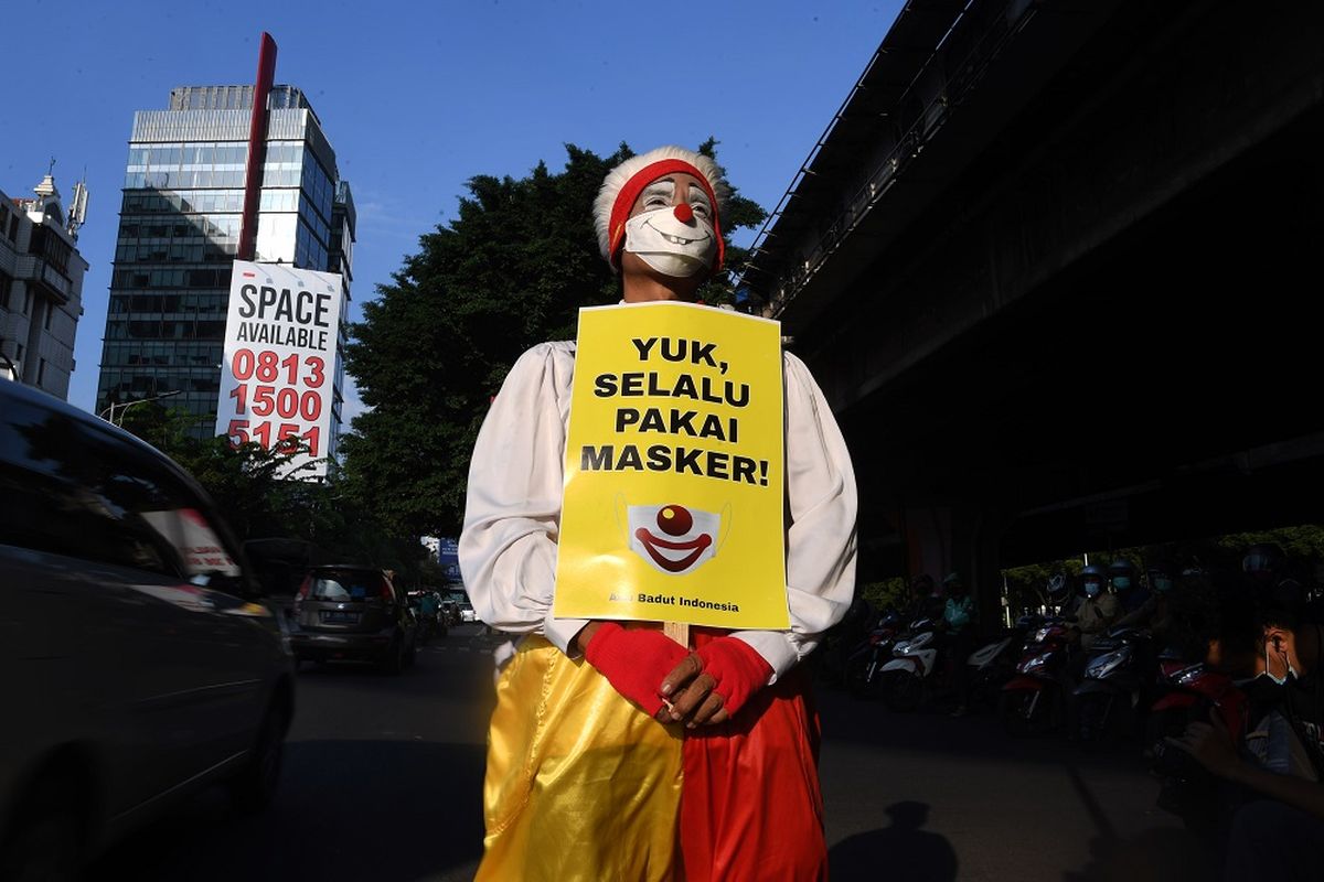 Seorang anggota komunitas Aku Badut Indonesia (ABI) melakukan aksi dengan mambawa poster di kawasan Fatmawati Jakarta, Senin (12/7/2021). Aksi tersebut untuk mengajak masyarakat menerapkan protokol kesehatan untuk mencegah penyebaran COVID-19 yang terus meningkat. ANTARA FOTO/Wahyu Putro A/foc.
