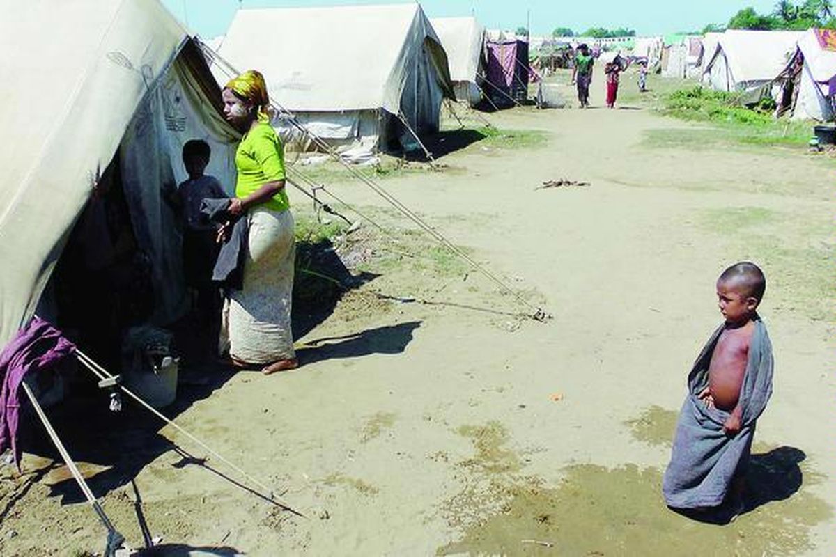 Seorang anak pengungsi berdiri di depan salah satu tenda di kamp pengungsi di Sittwe, ibu kota Negara Bagian Rakhine, Myanmar barat, Selasa (30/10). Lebih dari 32.000 orang mengungsi dalam sepekan terakhir akibat gelombang kerusuhan yang kembali terjadi.