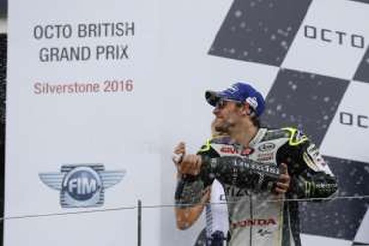 Pebalap LCR Honda asal Inggris, Cal Crutchlow, menyemprotkan sampanye untuk merayakan keberhasilannya finis di urutan kedua pada balapan GP Inggris di Sirkuit Silverstone, Minggu (4/9/2016).