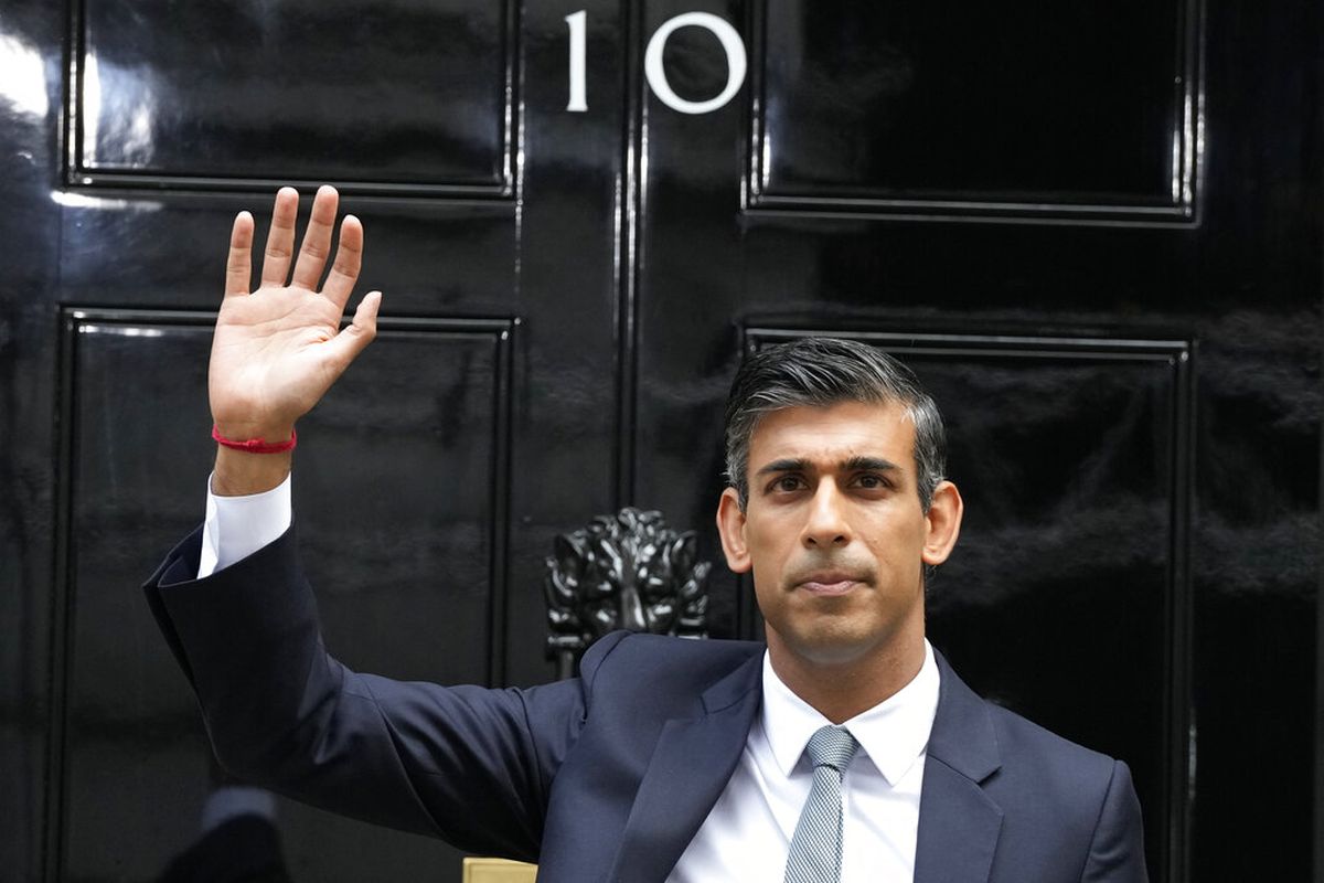 Perdana Menteri Inggris yang baru Rishi Sunak melambaikan tangan setelah tiba di Downing Street di London, Selasa, 25 Oktober 2022, usai kembali dari Istana Buckingham di mana ia secara resmi ditunjuk oleh Raja Inggris Charles III.
