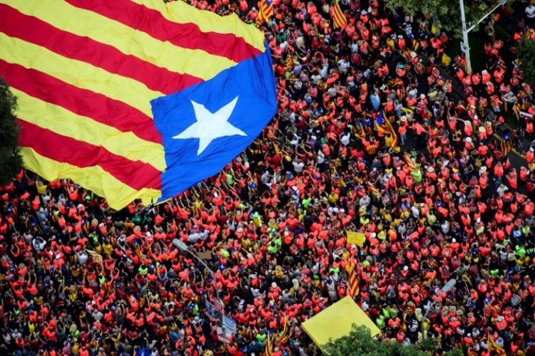 Warga memenuhi jalan sambil membentangkan bendera Catalonia raksasa untuk unjuk rasa menuntut kemerdekaan pada peringatan Hari Nasional Catalonia Diada, Selasa (11/9/2018). (AFP/Roser Vilallonga/Catalan National Assembly)
