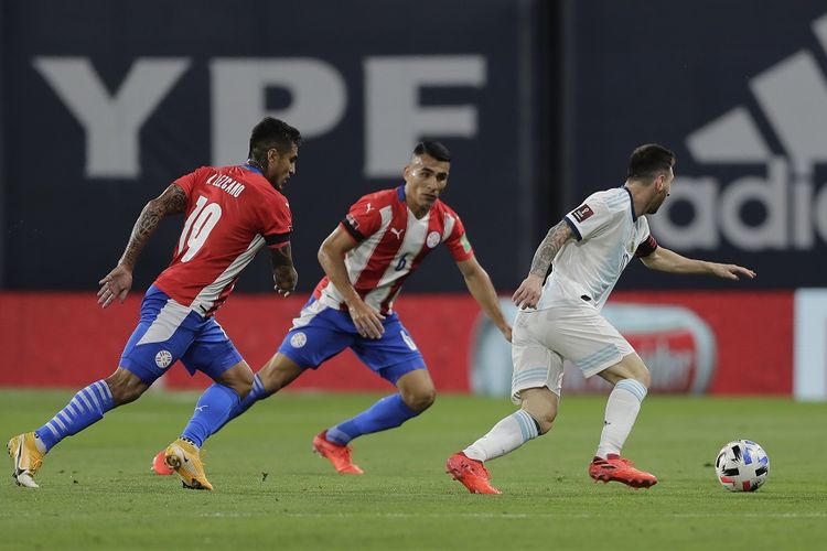 Pemain Argentina Lionel Messi (kanan) membawa bola di sebelah Dario Lezcano (kiri) dan Junior Alonso dari Paraguay pada pertandingan Argentina vs Paraguay dalam Kualifikasi Piala Dunia 2022 di Stadion La Bombonera di Buenos Aires pada 12 November 2020.