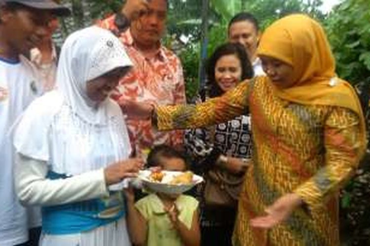 Menteri Sosial Khofifah Indar Parawansa, menyerahkan potongan tumpeng tanda syukur kepada penerima bantuan perbaikan rumah tidak layak huni (RTLH) di Kelurahan Buring, Kecamatan Kedung Kandang, Kota Malang, Jawa Timur, Minggu (13/3/2016).