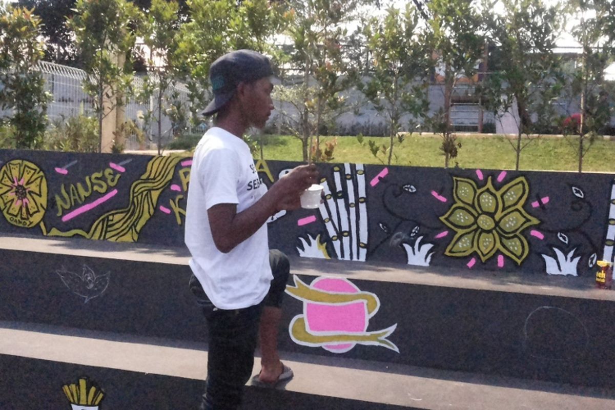 Seorang seniman mural yang tengah menghiasi dinding RPTRA Kecapi di Kebagusan, Pasar Minggu, Jakarta Selatan, Minggu (12/3/2017). Kegiatan menghias RPTRA dengan mural diinisiasi oleh komunitas Artsip Jakarta.