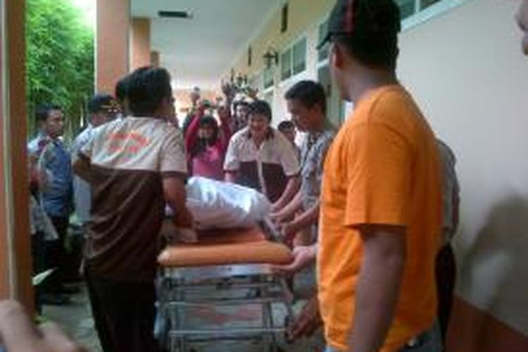 Mayat Moh Hapit (37), seorang buruh harian lepas, saat dibawa tim medis dari kamar hotel, Rabu (20/11/13)