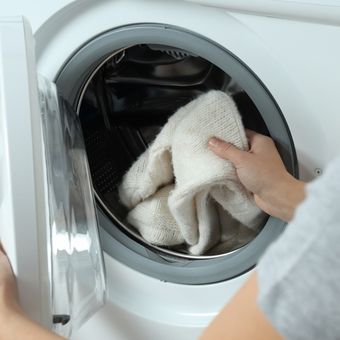 Ilustrasi mencuci pakaian di mesin cuci.