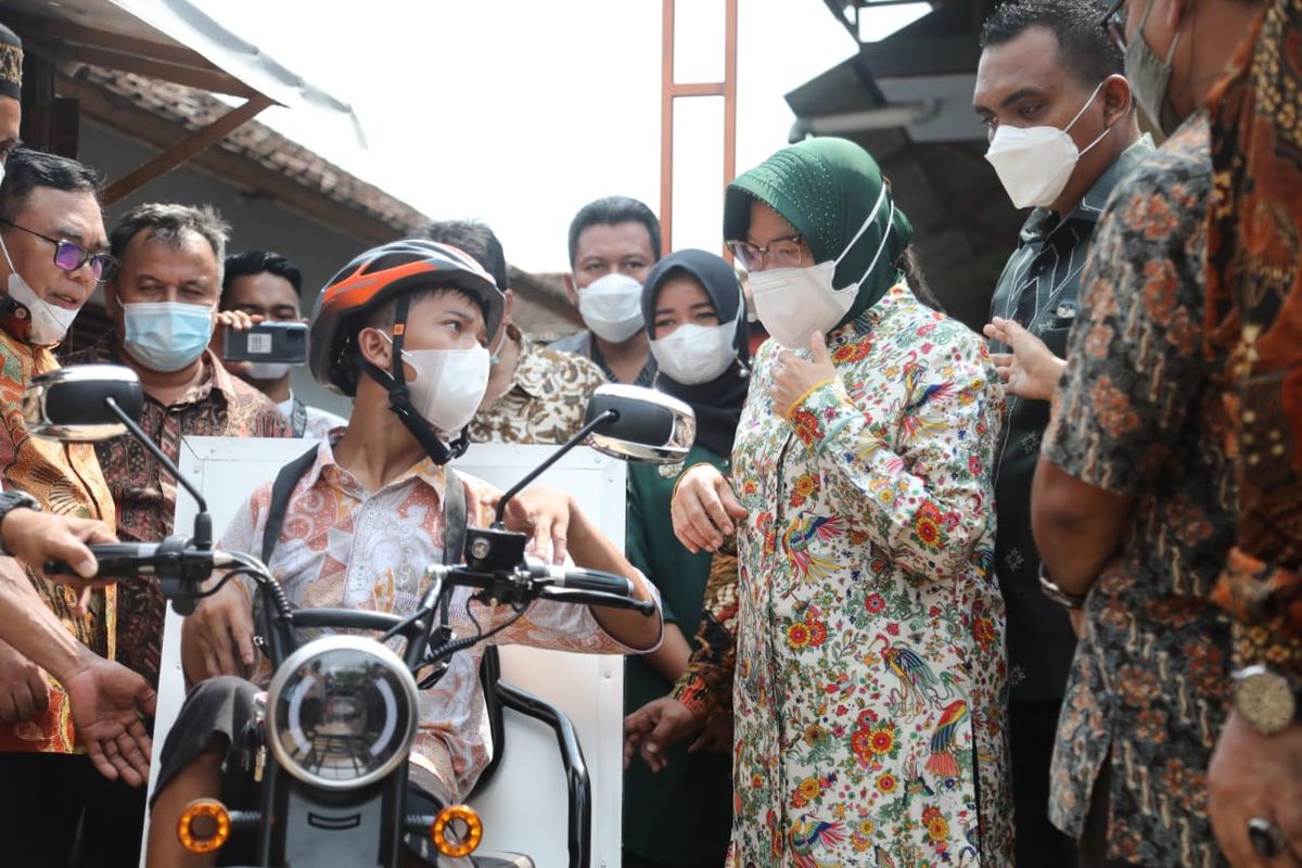 Menteri Sosial Tri Rismaharini Menyerahkan sepeda motor roda tiga kepada penyandang disabilitas fisik Gading Ogi Saputra (17) di Pekalongan, Minggu (16/5/2021).