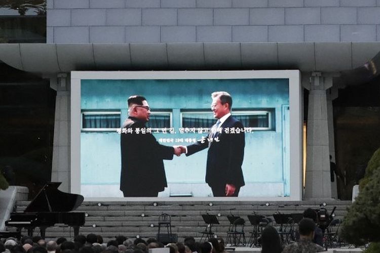 Sebuah layar yang menunjukkan gambar Presiden Korea Selatan Moon Jae-in dan pemimpin Korea Utara Kim Jong Un terlihat selama upacara untuk menandai ulang tahun pertama deklarasi Panmunjom antara Moon dan Kim yang diadakan pada 27 April 2018, di selatan sisi Panmunjom di Zona Demiliterisasi (DMZ) pada 27 April 2019.