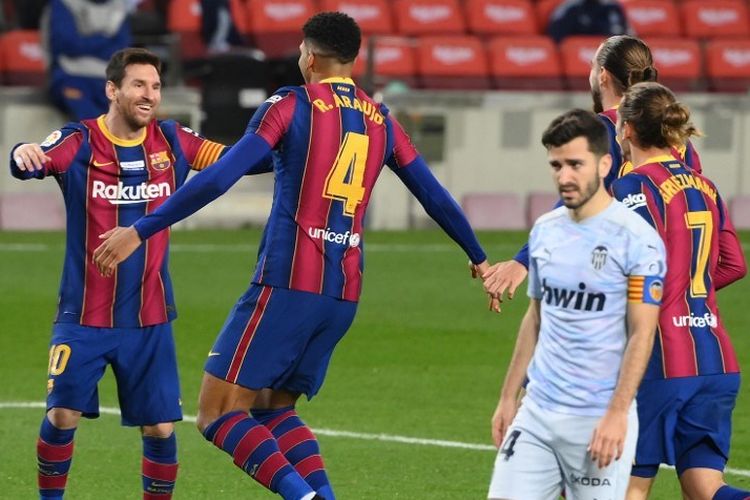 Bek Uruguay Barcelona Ronald Araujo (2L) merayakan golnya bersama penyerang Argentina Barcelona Lionel Messi selama pertandingan sepak bola liga Spanyol antara FC Barcelona dan Valencia CF di stadion Camp Nou di Barcelona pada 19 Desember 2020.