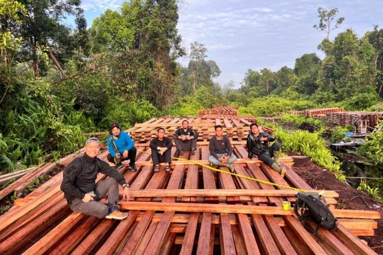 Petugas Satreskrim Polres Inhu, Riau, saat menemukan kayu illegal logging yang sudah diolah pelaku, Rabu (10/12/2025).