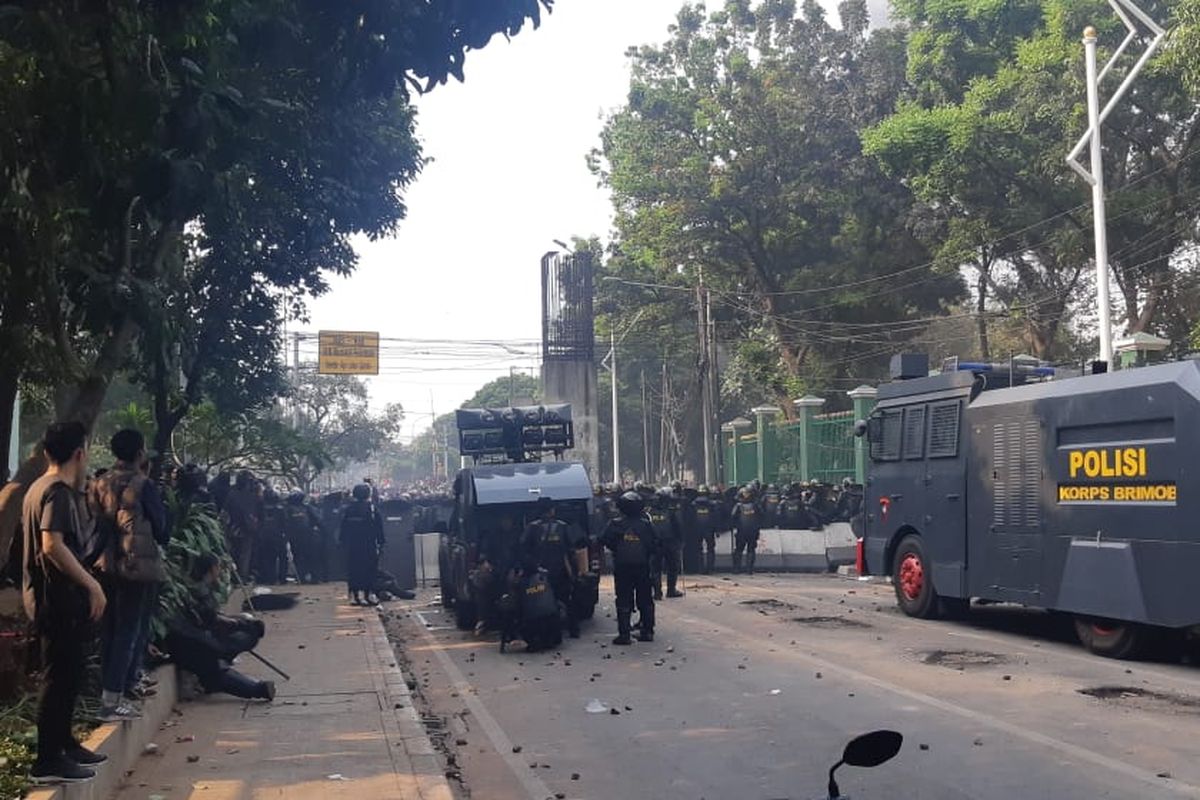 Polisi bersiaga di pintu belakang Kompleks DPR RI, Jalan Gelora, Jakarta Pusat, Rabu (25/9/2019). Mereka berupaya menghalau massa pelajar yang berupaya masuk ke Gedung DPR.