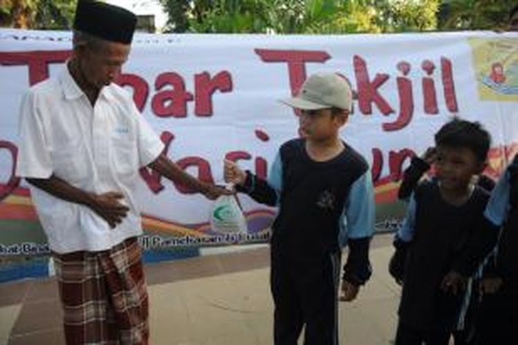 Siswa dan siswi dari salah satu taman kanak-kanak di Pamekasan berbagi takjil kepada warga, Rabu (24/7/2013).