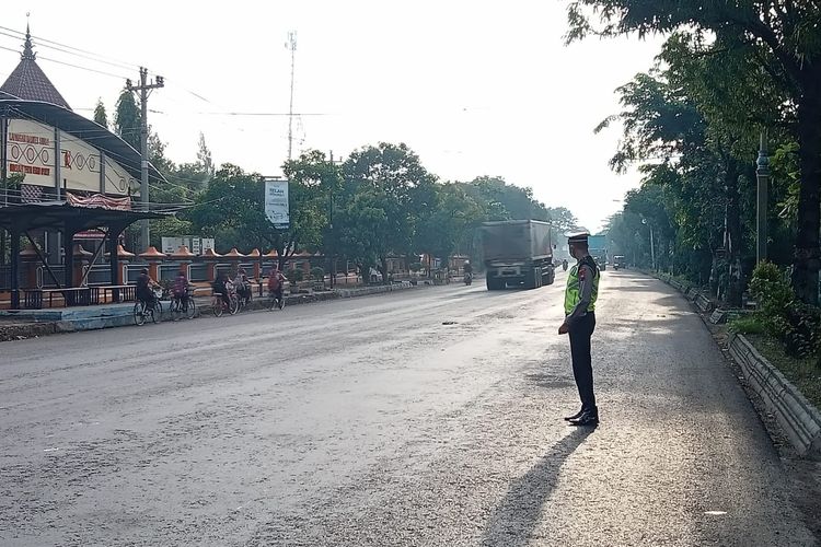 Seorang polisi sedang memantau kendaraan yang melintas di jalur pantura Pati - Rembang