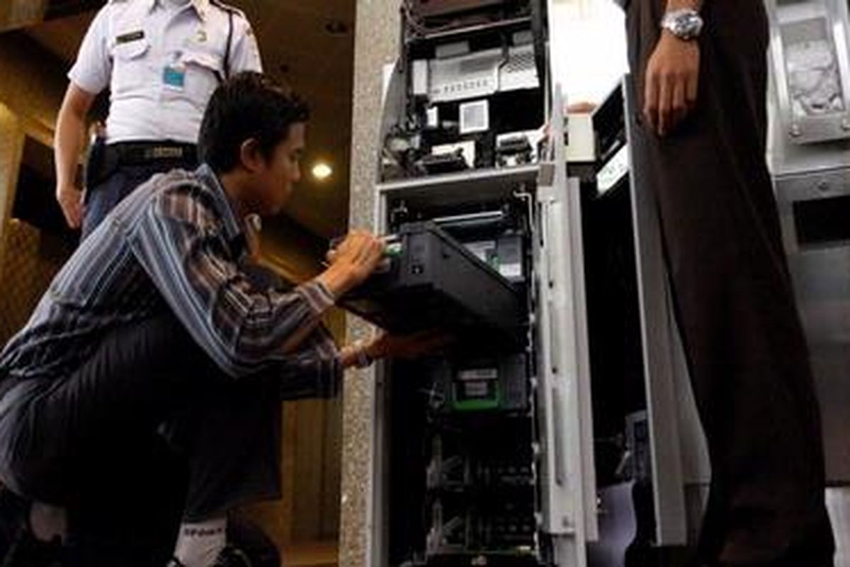 Seorang petugas tengah memasukkan kotak uang pada mesin Anjungan Tunai Mandiri (ATM) di Jakarta, Selasa (7/4/2009). 