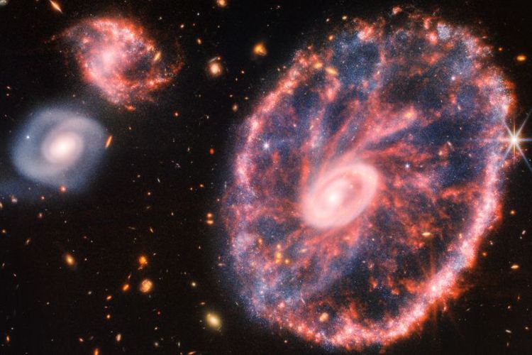 Gambar Galaksi Cartwheel dan dua galaksi pendampingnya yang berhasil dibidik Teleskop Luar Angkasa James Webb. Gambar galaksi ini jauh lebih detil dibandingkan yang pernah diambil sebelumnya.