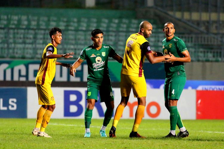 Pemain Persebaya Surabaya Riswan Lauhim dan Leo Lelis (hijau) dijaga ketat pemain Persikabo 1973 saat pertandingan tunda pekan ke-18 Liga 1 2022-2023 yang berakhir dengan skor 3-2 di Stadion Gelora Joko Samudro Gresik, Sabtu (25/3/2023) malam.