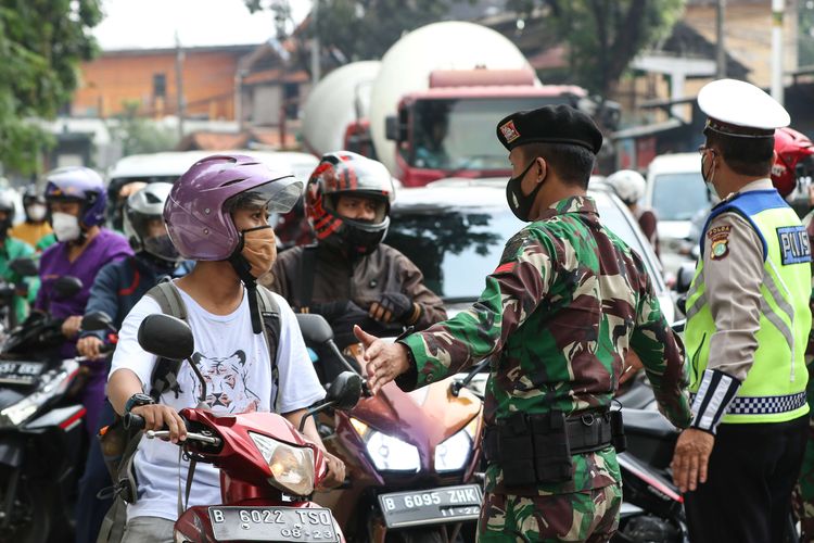 Anggota TNI dan Polri melakukan penyekatan kendaraan saat PPKM Darurat di Jalan Raya Lenteng Agung, Jakarta Selatan, Senin (5/7/2021). Penyekatan ini mengakibatkan kemacetan parah di ruas Jalan Raya Lenteng Agung.