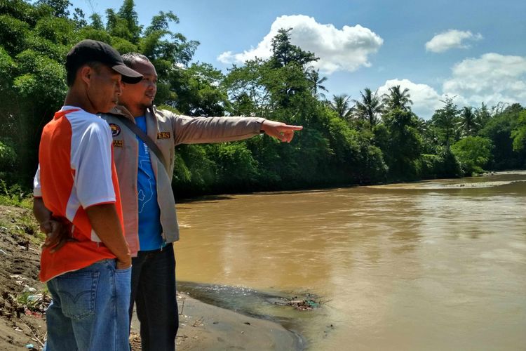 Supriyanto (kaos oranye) berdiri di pinggir sungai Progo, Dusun Jati, Desa Kalinegoro, Kecamatan Mertoyudan, Kabupaten Magelang, mencari Ulum (11) anaknya yang hanyut sejak Rabu (6/12/2017) sore.