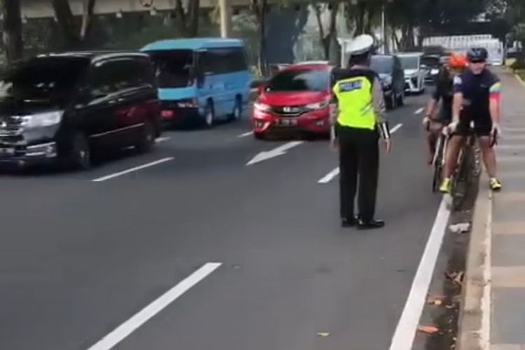 Petugas kepolisian memberhentikan dua pesepeda jenis road bike yang melintas di luar jalur sepeda di Jalan Jenderal Sudirman tepatnya di lingkar Semanggi bawah, Jakarta Selatan, Jumat (9/12/2022).