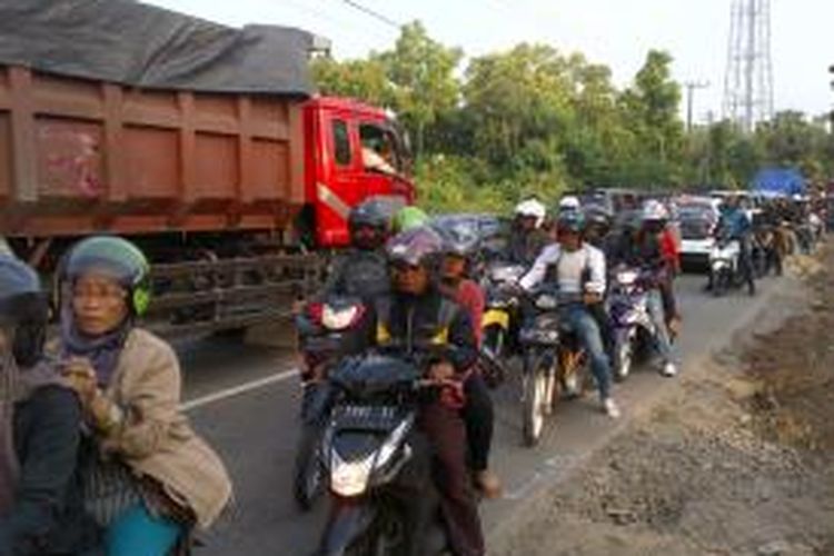 Kendaraan dari dua arah di Kecamatan Blega saling menerobos karena kemacetan akibat perbaikan jalan, Ahad (29/12/2013).