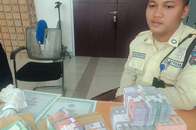 Sekuriti Kereta Api Bandara Medan menunjukkan uang milik penumpang yang ditemukan di Stasiun Kereta Api Bandara Medan di Jalan Jawa, Kota Medan, Senin (22/4/2024).

